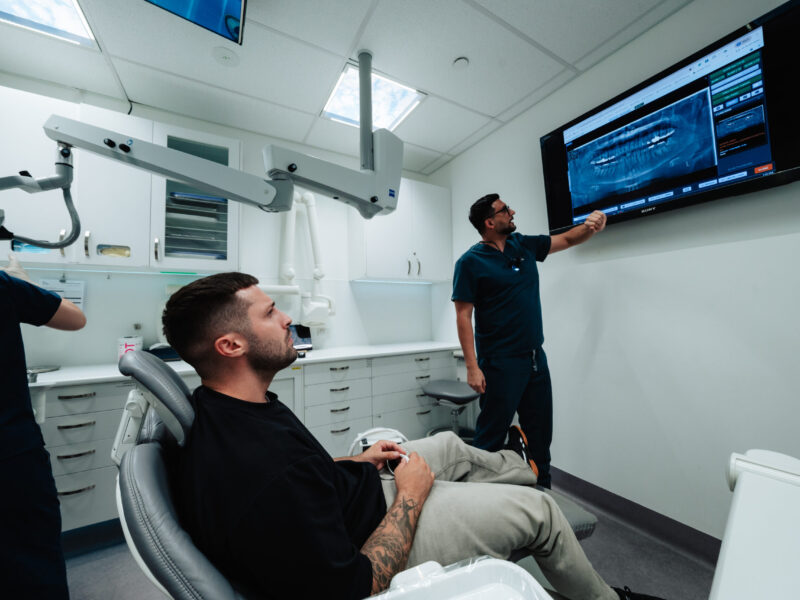 Dentist explaining panoramic dental X-ray results to a patient on screen at Pure Dentistry in Brisbane
