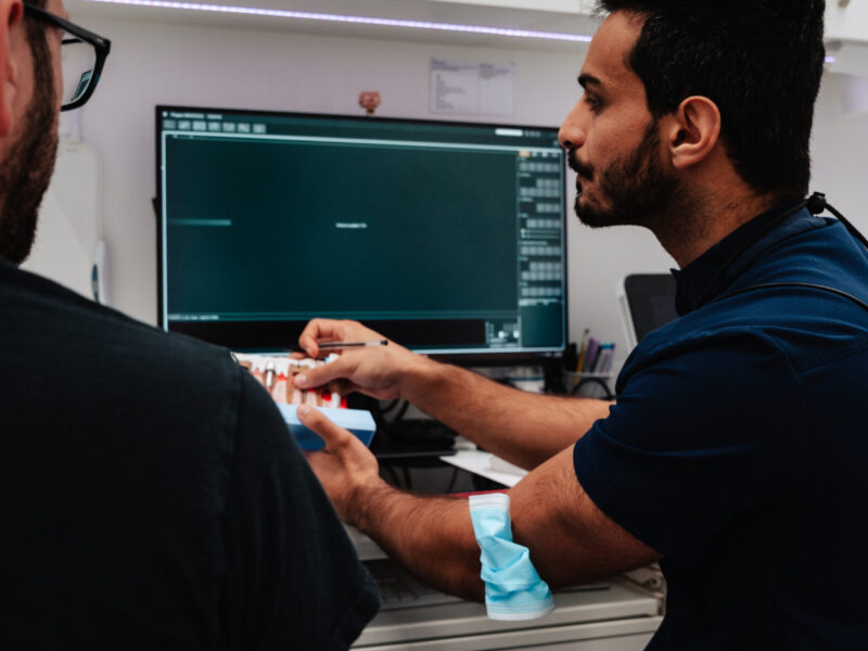 Dentist using a dental model to explain treatment options to a patient at Pure Dentistry in Brisbane