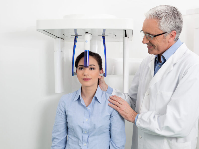 Dentist positioning a patient for a CBCT dental scan