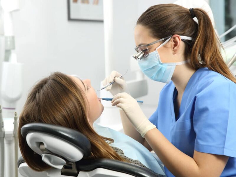 female dentist checking patient's teeth